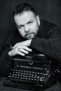 Kuvassa kirjailija Christian Rönnbacka ja vanha Remington-kirjoituskone.